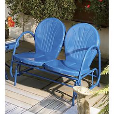 two blue chairs sitting next to each other on a patio