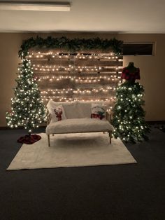 a living room decorated for christmas with lights on the wall and trees in the corner