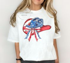 You need this American Coquette Cowgirl hat designT-shirt, a unique and patriotic addition to your wardrobe for all Memorial Day or July 4 celebrations! This red, white, and  blue cowgirl hat T-shirt features a chic coquette bow design with a trendy cowgirl hat that adds a touch of western flair to your outfit. Made from high quality Comfort Colors brand T-shirts,  it's both stylish and comfortable to wear. Stand out and show off your American pride with his American coquette cowgirl hat T-shirt Patriotic Red Tops For Veterans Day, Red Patriotic Tops For Veterans Day, White Cotton Top For Country Events, White Cotton Tops For Country Events, White Tops For Country Events In Summer, Red Patriotic Tops, White Americana T-shirt For Summer, Blue Cowgirl Hat, American Coquette