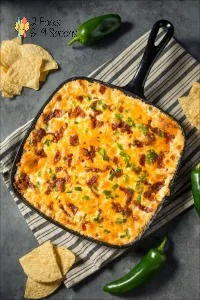 a casserole with cheese, bacon and jalapenos on the side