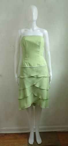 "Pretty cocktail party dress in lime green chiffon. Band of beads and tiered skirt details. Princess seamed bodice with boning to keep dresss in place. Looser cut through hips. Fully lined. condition: excellent color(s): pale green fabric(s): poly chiffon shell / polyester lining brand: none care: dry clean --- measurements --- ✩ size is estimated - please double check measurements for best fit estimated size: xs ✩ all measurements are taken with the item laying flat ✩ bust, waist, and hip measu Chiffon Ruffle Dress, Strapless Party Dress, Pretty Cocktails, Chiffon Ruffle, Cocktail Party Dress, Pale Green, Beaded Dress, Green Fabric, Ruffle Dress