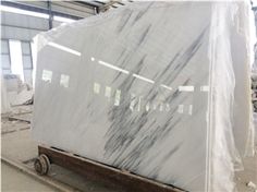 a large white marble slab sitting on top of a wooden pallet in a warehouse