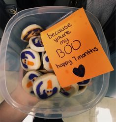 a plastic container filled with cookies covered in frosted icing and writing on it