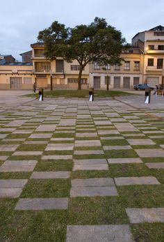 an empty park with benches and trees in the background at dusk or dawn, on a cloudy day