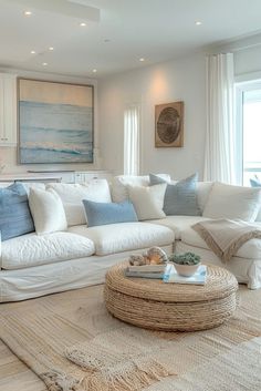 a living room filled with white furniture and lots of pillows on top of the couch