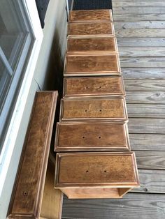 a stack of drawers sitting on top of a wooden floor next to a window sill