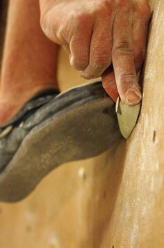 a man is holding a hammer and sanding on the wall