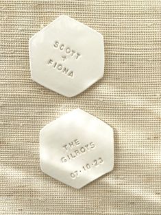 two white tags with the words scott and roma on them are placed next to each other