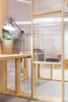 a desk with a lamp on top of it next to a wooden shelf filled with books