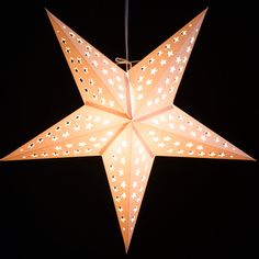 a lighted star hanging in the dark with stars on it's back and sides