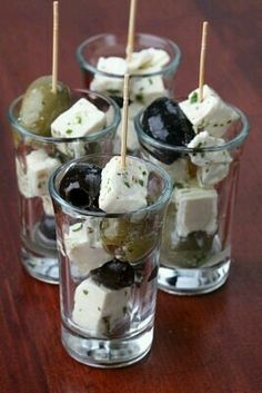 olives and cheese appetizers with toothpicks in glass cups