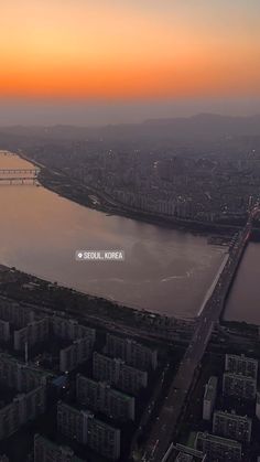 an aerial view of the city and water at sunset