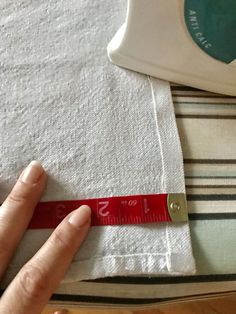 someone is measuring the length of a towel with a red tape on top of it