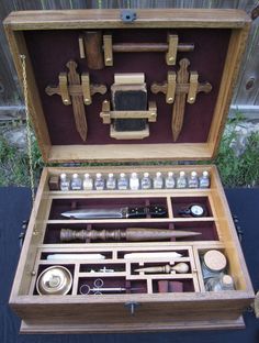 an open wooden box with various items inside