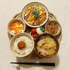 several bowls of food are arranged on a tray