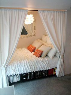 a bed with white sheets and pillows in front of a mirror