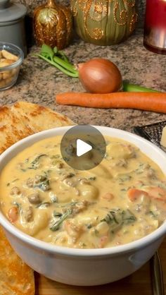 a white bowl filled with soup next to some bread