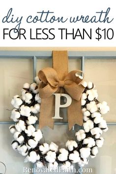 a cotton wreath with the letter p on it is hung on a door and has a brown bow