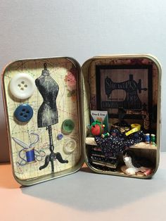 an open tin box with sewing supplies inside