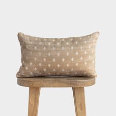 a pillow sitting on top of a wooden stool