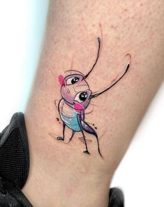 a small tattoo on the leg of a person with a pink and blue ballerina