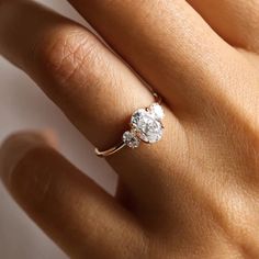 a woman's hand with a diamond ring on top of her finger and an engagement band