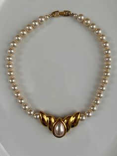 A beautiful vintage choker collar length necklace by Napier. Circa 1970's-1980's.  It has I larger oval faux pearl in a bezel gold plated setting in the center of the faux pearl necklace.  It is marked on the back of the pendant : Napier, and it is also marked on the fold over clasp.  The necklace measures approximately 16 1/2 inches long. The pendant measures 2 inches wide, and 1 inch long.  It is stunning and in excellent vintage condition! Classic Gold Pearl Choker Necklace, Vintage Pearl Choker Necklace For Formal Occasions, Vintage Pearl Choker Necklace, Classic Gold Pearl Choker, Victorian Gold Pearl Necklace Gift, Vintage Pearl Chain Choker For Gift, Vintage Yellow Gold Pearl Necklace Gift, Napier Jewelry Vintage, Vintage Multi-strand Pearl Necklace As Gift