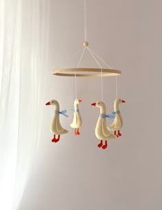 three ducks are hanging from a wooden mobile