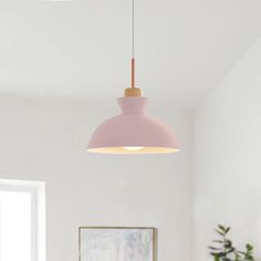 a pink lamp hanging over a dining room table