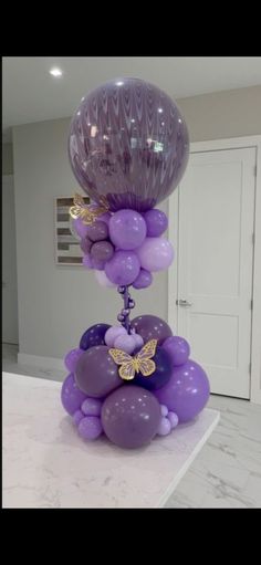 purple balloons are stacked on top of each other in the middle of a kitchen counter