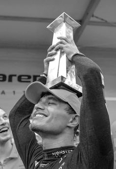 a man holding up a trophy in front of his face with other people behind him