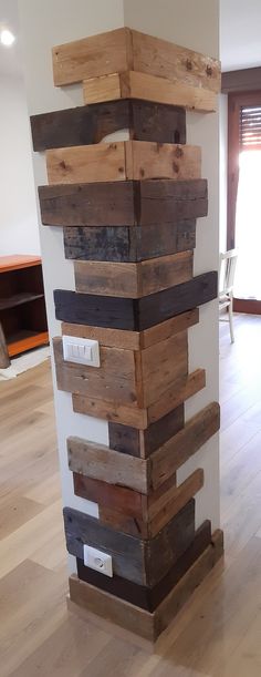 a tall stack of wood sitting on top of a hard wood floor