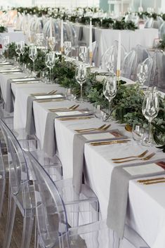 a long table is set up with place settings for formal dinnereons and wine glasses