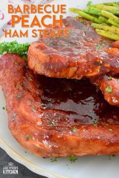 barbecue peach ham steaks on a plate with asparagus