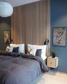 a bedroom with blue walls and wooden slats on the headboard is pictured in this image