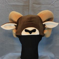 Ultrasoft fleece BIG HORN SHEEP or RAM ear hat with freestanding, 3D diamond ears, a solid brown base, white muzzle block, black nose, large curling plush tan horns, and white ear lining.  This hat's cozy layers will keep you warm through the coldest days! Perfect for cold weather outdoor fun, a costume, or to make a statement.  Will fit most adults.  Multiple color variations are available so PLEASE specify which color style is preferred. If choosing the Custom Colors option, please write your Big Horn Sheep, 3d Diamond, Black Nose, Fleece Hat, Solid Brown, Ear Hats, Skull Cap Beanie, Natural Colors, Outdoor Fun