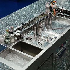 a stainless steel kitchen sink filled with lots of utensils