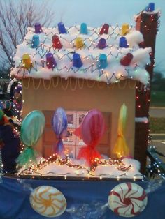 a house made out of balloons and candy canes on top of snow covered ground