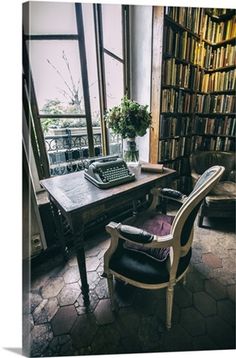 an old fashioned desk and chair in front of a bookcase with books on it