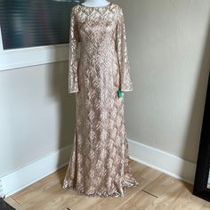 a dress is on display in front of a wall with a framed photo behind it