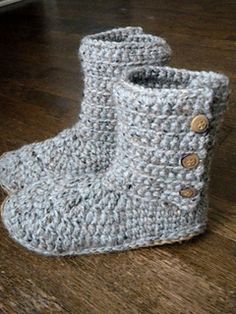 a pair of crocheted boots sitting on top of a wooden floor