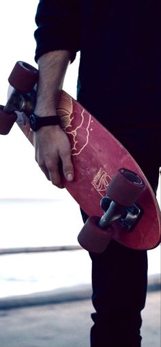 a close up of a person holding a skateboard with both hands on the board