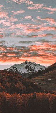 the sky is red and white as the sun sets in the distance with mountains in the background