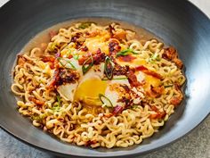 a bowl filled with noodles and an egg on top