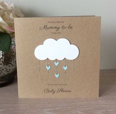 a card with a cloud and hearts hanging from it's side on a table