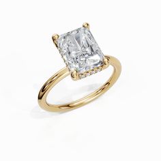 a yellow gold ring with a square cut diamond in the center, surrounded by small round diamonds