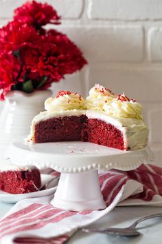 a red velvet cake with white frosting and sprinkles on a plate