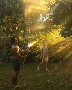 two men are spraying water on each other with hoses in front of their faces