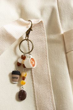 a keychain with coffee charms hanging from it's side on a white shirt