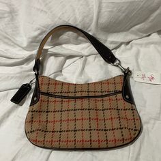 Coach Brown Leather Accents With Tan Plaid Wool With Red And Brown Stripes Through The Plaid . The Tan Is The Perfect Tan Shade . Deep Chocolate Brown Leather . This Purse Is Nwt And In Perfect Condition Free Of Rips Stains Holes Or Smells. Fall Coach Shoulder Bag With Zipper Pocket, Coach Bags With Leather Trim For Fall, Coach Bag With Leather Trim For Fall, Vintage Beige Shoulder Bag With Zipper Closure, Vintage Bags With Zipper Closure For Fall, Retro Beige Bag With Zipper Closure, Retro Beige Shoulder Bag With Zipper Closure, Coach Shoulder Bag With Leather Handles For Fall, Coach Shoulder Bag For Fall Shopping